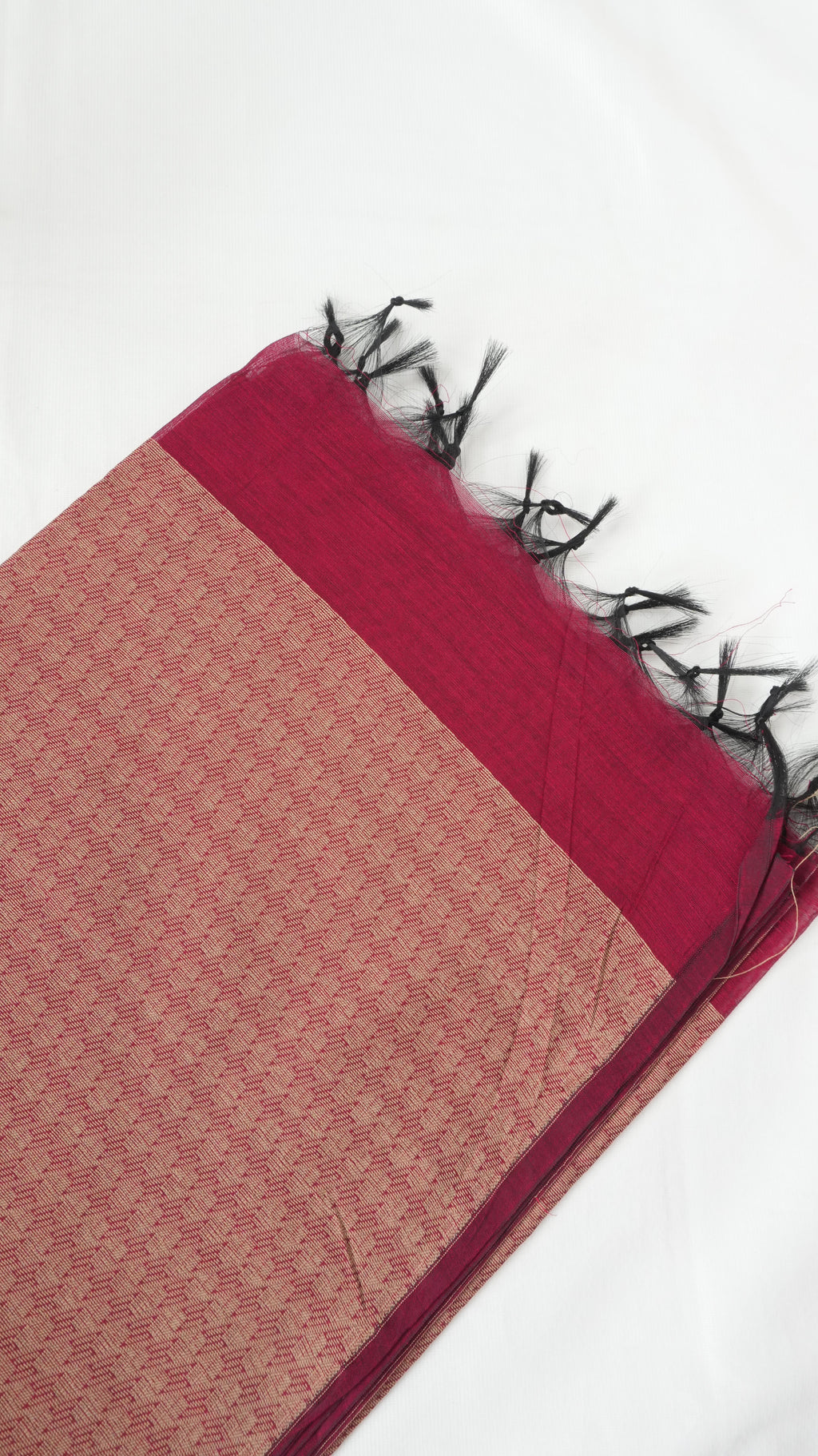 Silk cotton saree folded showing copper zari woven pallu and red body with floral buttas